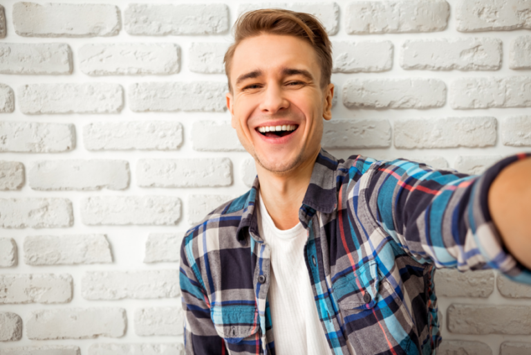 Young man laughing, taking a selfie