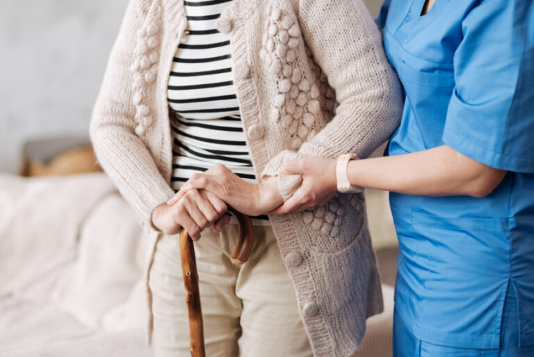Photograph of a caregiver helping elderly woman