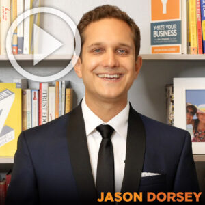 Jason wearing suit in front of bookshelf with a play button on top left corner