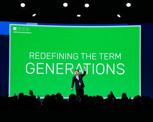 Jason-dorsey-on-stage-with-big-screen-projecting-slide-saying-redefining-the-term-generations